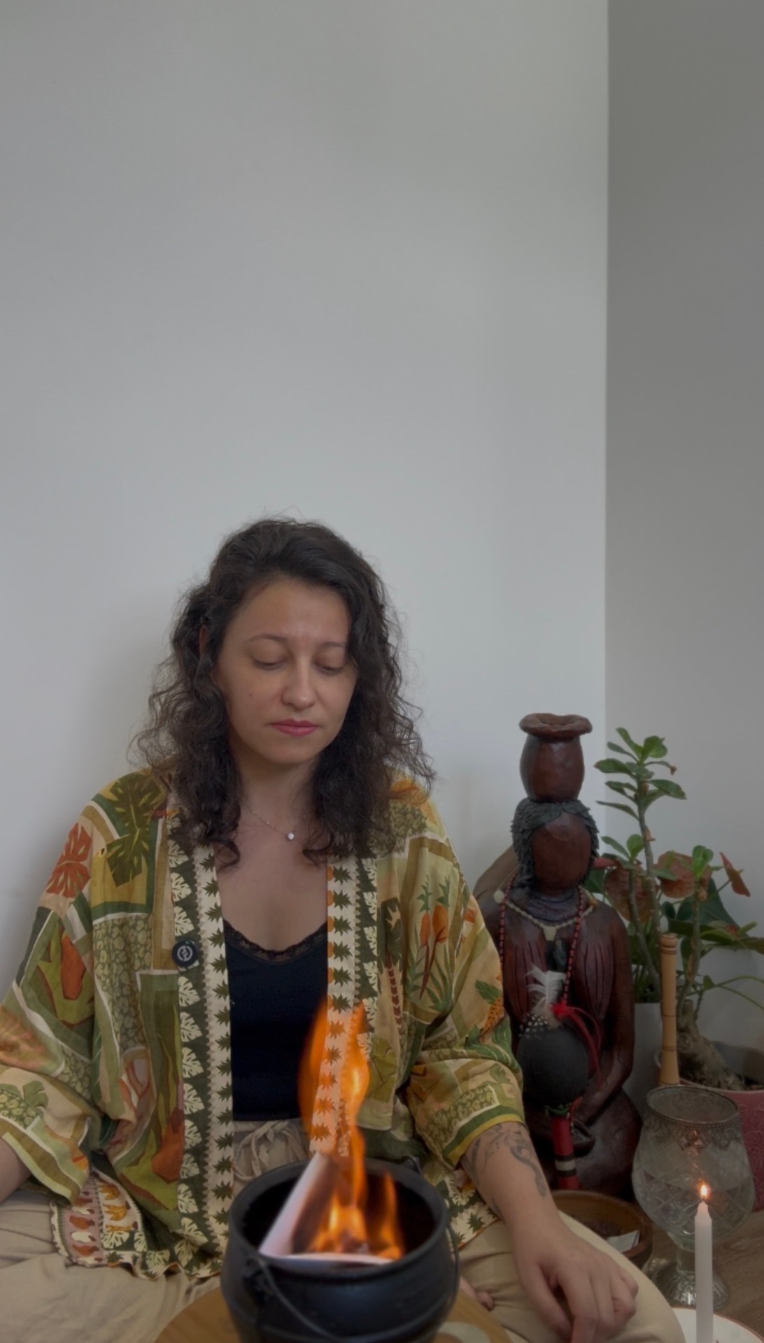 Carol Lana em ritual, sentada diante do fogo sagrado